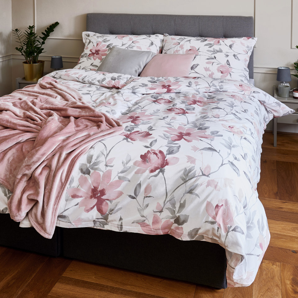 Fotografie postele, kde je povlečení s magnoliemi od SCANquilt, česká značka povlečení
